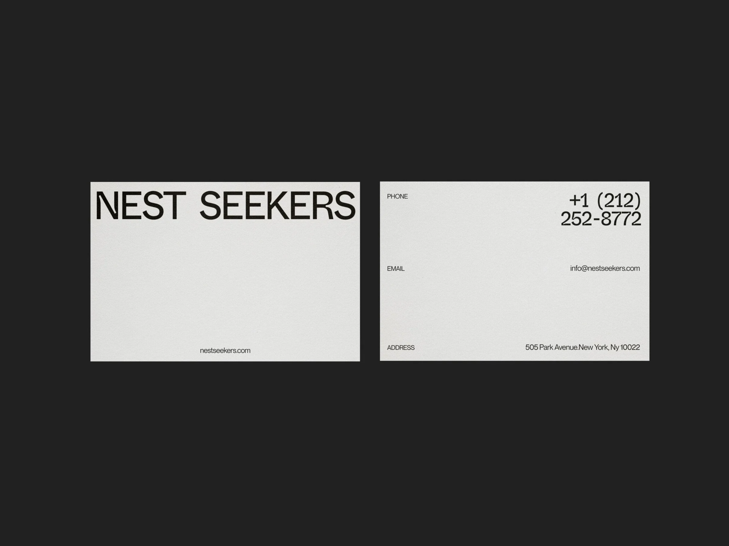 Front and back of white business cards with black wordmark and contact details on a dark background, for Nest Seekers.