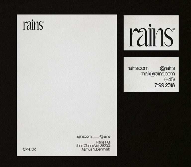 Letterhead and business card front and back with black serif wordmark on off-white paper over a black background, for Rains.