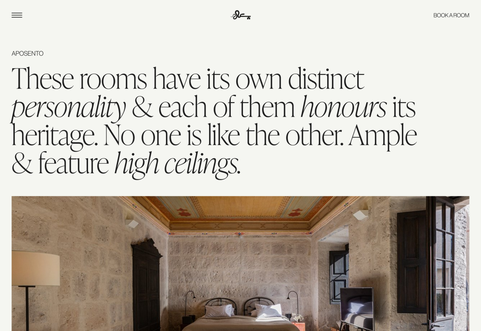 Website rooms page with serif headline about heritage rooms above a stone-walled bedroom with painted ceiling, for Cirqa.